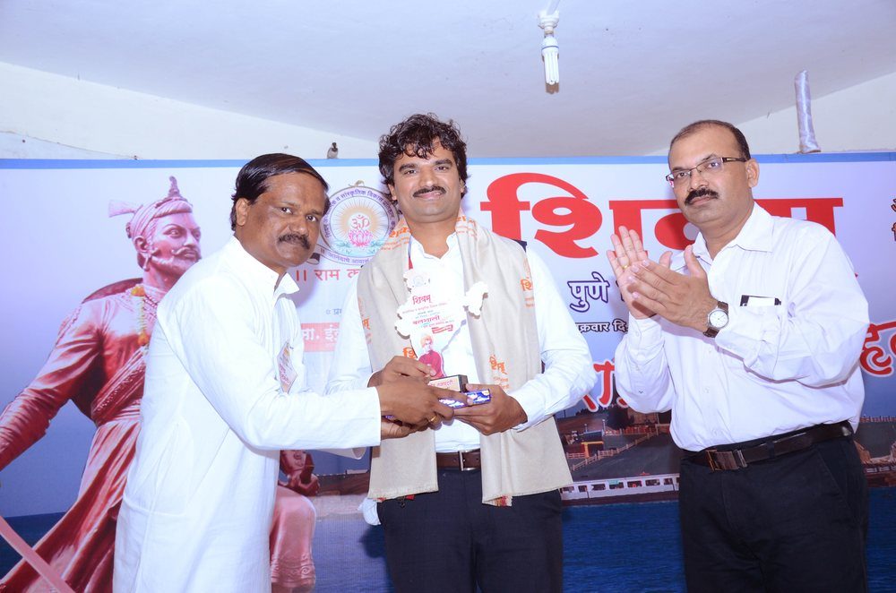 Santosh Talaghatti being felicitated on stage at a community award ceremony in Maharashtra